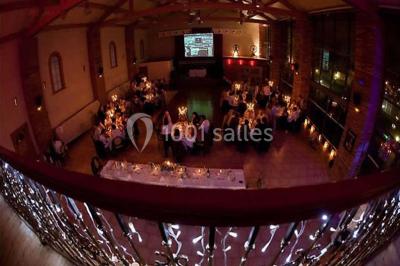 Un couple danse au centre d'une salle de réception éclairée par des lumières colorées et des étincelles.