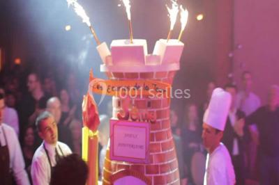 Un couple danse au centre d'une salle de réception éclairée par des lumières colorées et des étincelles.