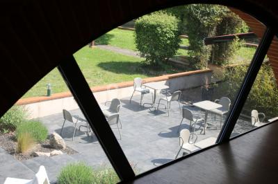 Table de billard en bois avec tapis vert dans une pièce au style rustique, avec poutres apparentes et murs en briques.