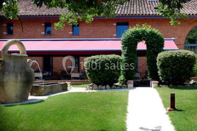 Table de billard en bois avec tapis vert dans une pièce au style rustique, avec poutres apparentes et murs en briques.