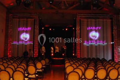 Table de billard en bois avec tapis vert dans une pièce au style rustique, avec poutres apparentes et murs en briques.