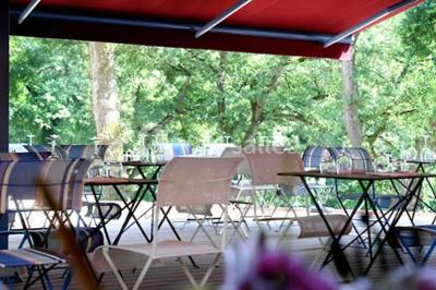 Table de billard en bois avec tapis vert dans une pièce au style rustique, avec poutres apparentes et murs en briques.