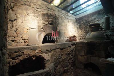 Fenêtre en bois éclairée par la lumière naturelle, avec un rebord recouvert de mousse et de petites bougies.