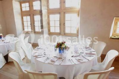 Fenêtre en bois éclairée par la lumière naturelle, avec un rebord recouvert de mousse et de petites bougies.