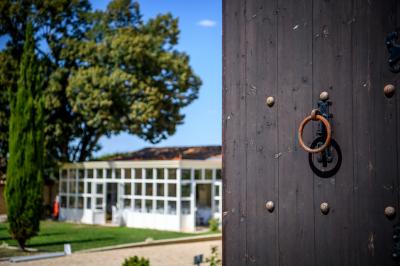 Une mariée en robe blanche marche sur une terrasse en bois, un enfant ajuste son voile sous un ciel dégagé.