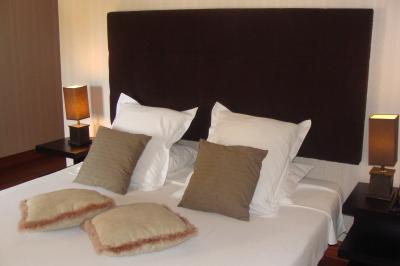 Une mariée en robe blanche marche sur une terrasse en bois, un enfant ajuste son voile sous un ciel dégagé.