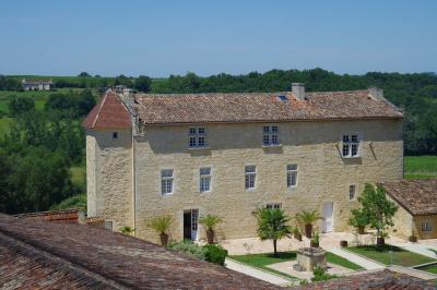 Une mariée en robe blanche marche sur une terrasse en bois, un enfant ajuste son voile sous un ciel dégagé.