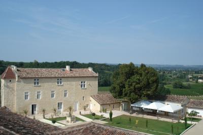Une mariée en robe blanche marche sur une terrasse en bois, un enfant ajuste son voile sous un ciel dégagé.