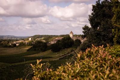 Une mariée en robe blanche marche sur une terrasse en bois, un enfant ajuste son voile sous un ciel dégagé.