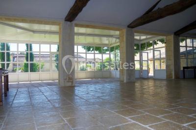 Rangées de fûts en bois alignés dans une cave en pierre éclairée par des lumières chaudes.