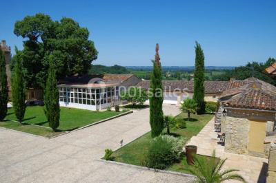 Rangées de fûts en bois alignés dans une cave en pierre éclairée par des lumières chaudes.