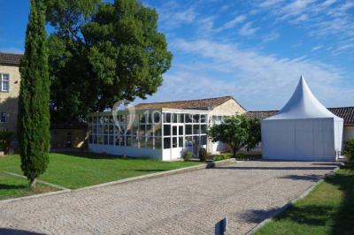 Rangées de fûts en bois alignés dans une cave en pierre éclairée par des lumières chaudes.