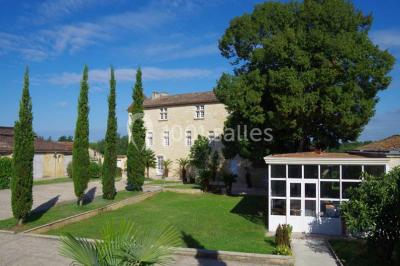 Rangées de fûts en bois alignés dans une cave en pierre éclairée par des lumières chaudes.
