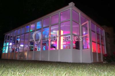 Rangées de fûts en bois alignés dans une cave en pierre éclairée par des lumières chaudes.