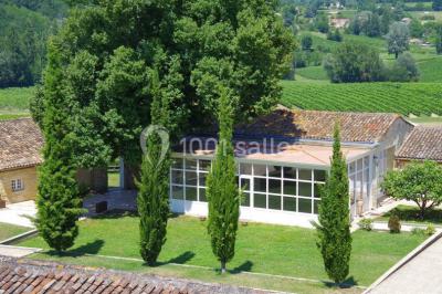 Rangées de fûts en bois alignés dans une cave en pierre éclairée par des lumières chaudes.
