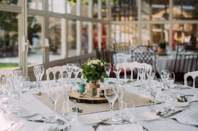 Rangées de fûts en bois alignés dans une cave en pierre éclairée par des lumières chaudes.