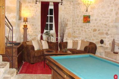 Rangées de fûts en bois alignés dans une cave en pierre éclairée par des lumières chaudes.