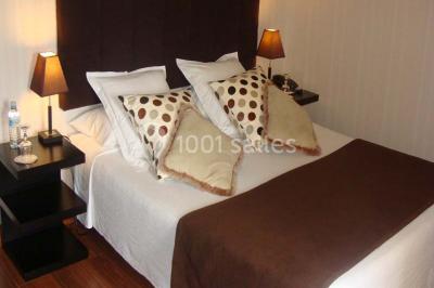 Rangées de fûts en bois alignés dans une cave en pierre éclairée par des lumières chaudes.