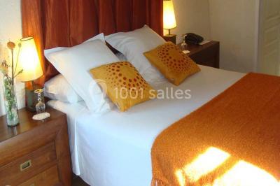 Rangées de fûts en bois alignés dans une cave en pierre éclairée par des lumières chaudes.