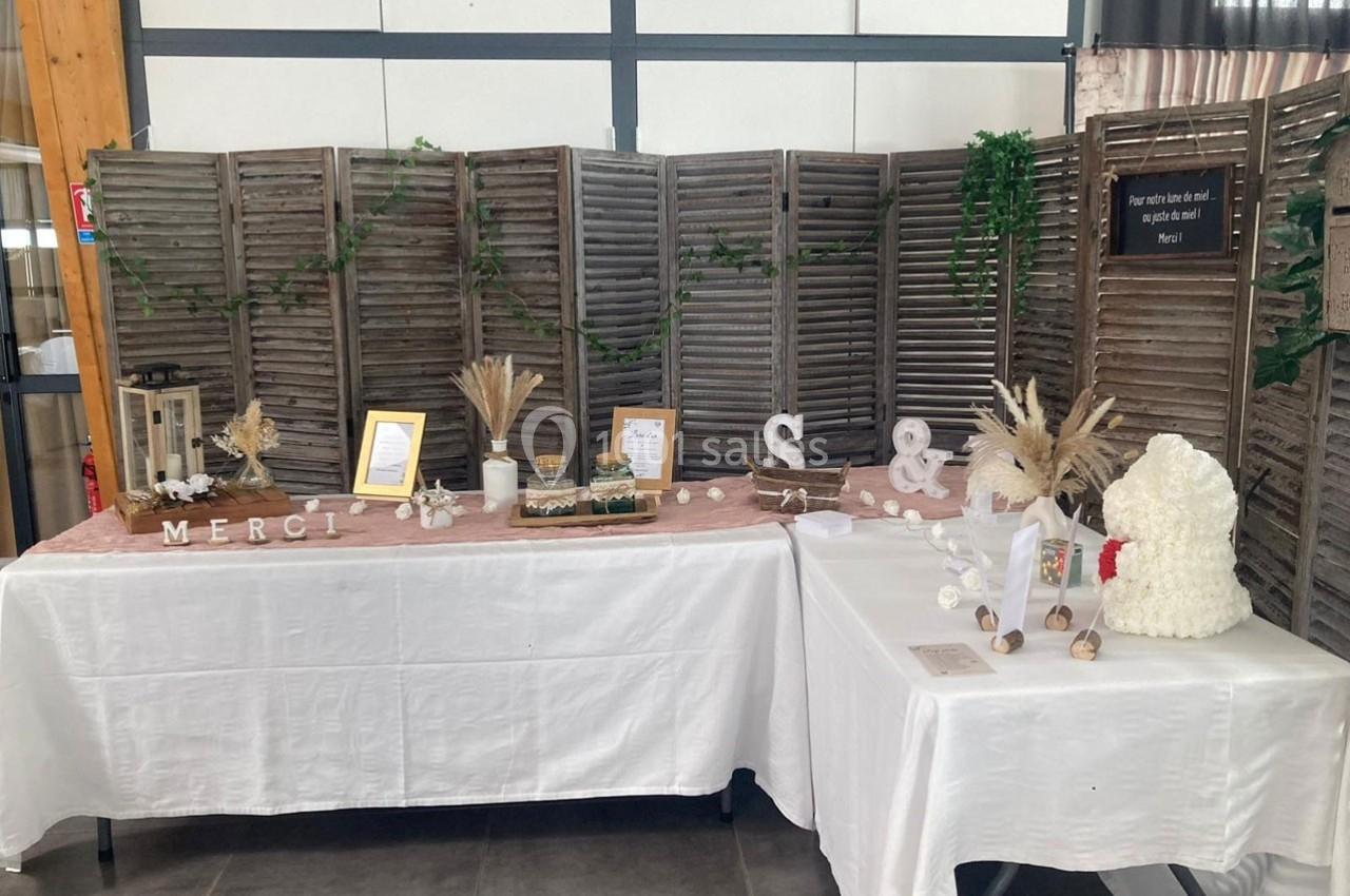 Table décorée pour un événement avec des éléments naturels, des cadres, des lettres décoratives et un paravent en bois.
