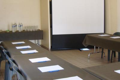 Terrain de mini-golf en plein air avec pelouse, arbres et parcours délimités par des bordures colorées.