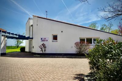Terrain de mini-golf en plein air avec pelouse, arbres et parcours délimités par des bordures colorées.