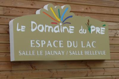 Cuisine professionnelle avec plan de travail en inox, lave-vaisselle industriel et casiers de rangement colorés.