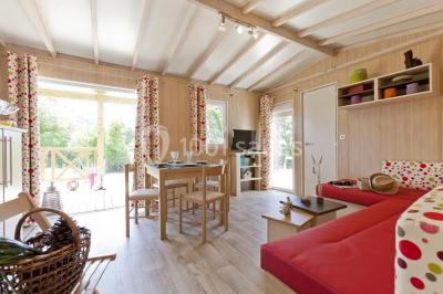 Cuisine professionnelle avec plan de travail en inox, lave-vaisselle industriel et casiers de rangement colorés.