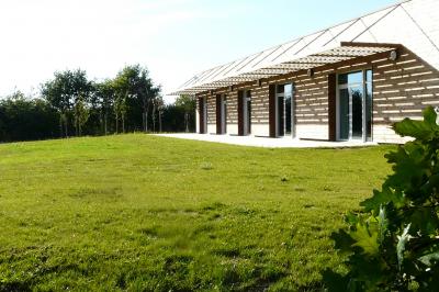 Cuisine professionnelle avec plan de travail en inox, lave-vaisselle industriel et casiers de rangement colorés.
