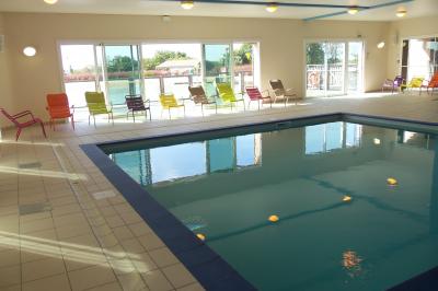 Cuisine professionnelle avec plan de travail en inox, lave-vaisselle industriel et casiers de rangement colorés.