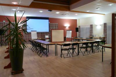 Cuisine professionnelle avec plan de travail en inox, lave-vaisselle industriel et casiers de rangement colorés.