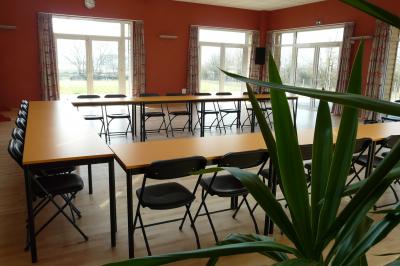 Cuisine professionnelle avec plan de travail en inox, lave-vaisselle industriel et casiers de rangement colorés.