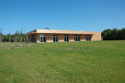 Cuisine professionnelle avec plan de travail en inox, lave-vaisselle industriel et casiers de rangement colorés.