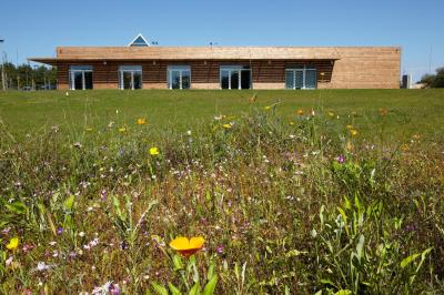 Cuisine professionnelle avec plan de travail en inox, lave-vaisselle industriel et casiers de rangement colorés.