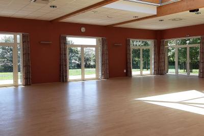 Cuisine professionnelle avec plan de travail en inox, lave-vaisselle industriel et casiers de rangement colorés.