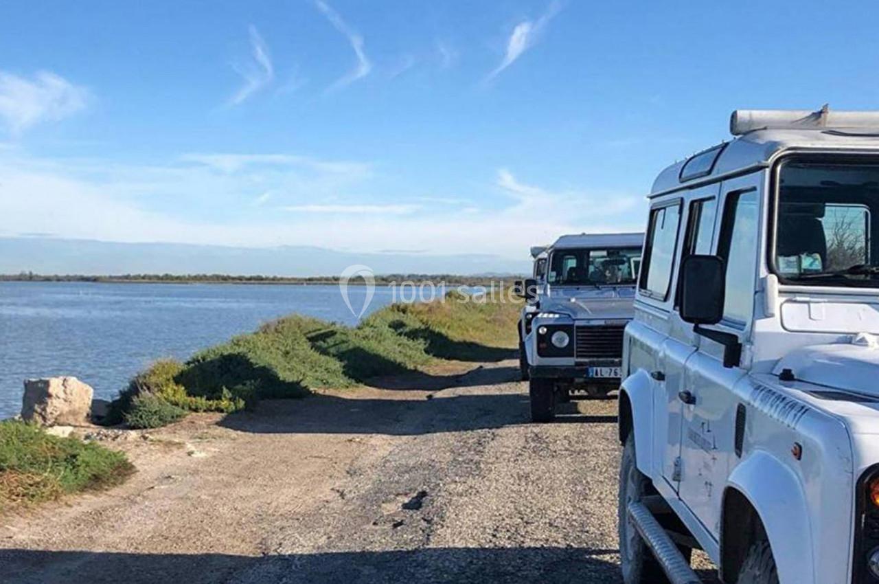 Deux véhicules tout-terrain stationnés sur un chemin en bord de lac sous un ciel dégagé.
