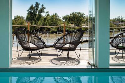 Salon lumineux avec canapé, table basse, tapis à motifs, et chambre en mezzanine avec lit double en arrière-plan.