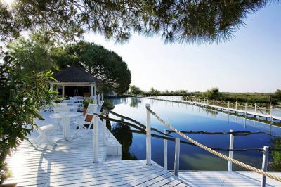 Salon lumineux avec canapé, table basse, tapis à motifs, et chambre en mezzanine avec lit double en arrière-plan.