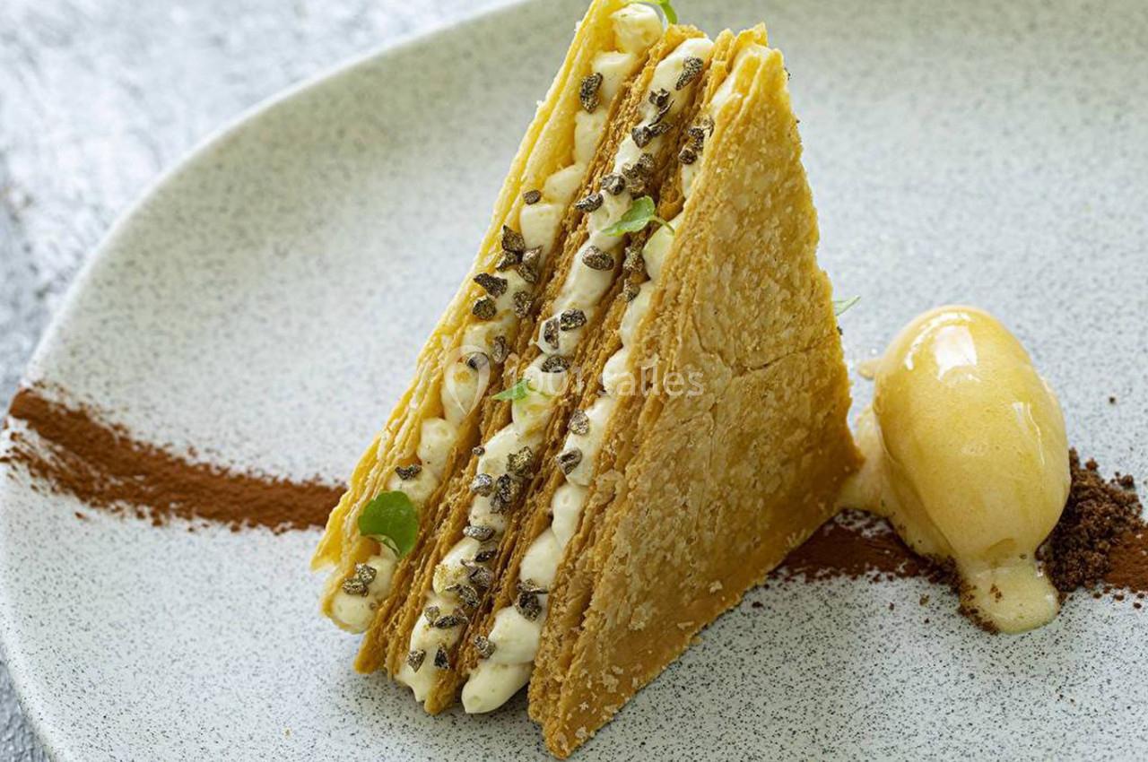 Dessert composé de couches de pâte feuilletée, crème garnie de truffes, accompagné d'une quenelle de glace.