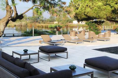 Salon lumineux avec canapé, table basse, tapis à motifs, et chambre en mezzanine avec lit double en arrière-plan.