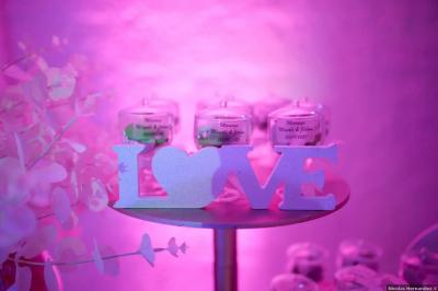 Pièce montée en choux avec figurines de mariés et une inscription en sucre, décorée d'une étincelle allumée.