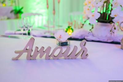 Pièce montée en choux avec figurines de mariés et une inscription en sucre, décorée d'une étincelle allumée.