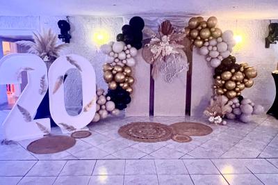 Pièce montée en choux avec figurines de mariés et une inscription en sucre, décorée d'une étincelle allumée.