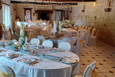 Chaises en bois disposées autour d'une petite table ronde avec un vase, sur une pelouse ensoleillée.