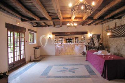 Chaises en bois disposées autour d'une petite table ronde avec un vase, sur une pelouse ensoleillée.