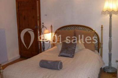 Deux fauteuils en rotin décorés, placés sous une arche ornée de fleurs et de tissus, dans un jardin verdoyant.