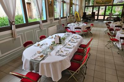 Deux fauteuils en rotin décorés, placés sous une arche ornée de fleurs et de tissus, dans un jardin verdoyant.