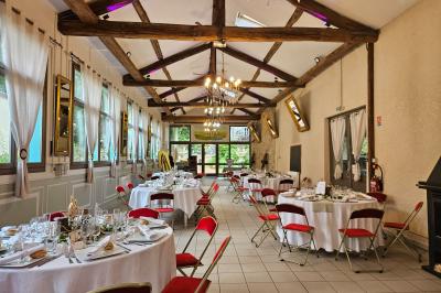 Deux fauteuils en rotin décorés, placés sous une arche ornée de fleurs et de tissus, dans un jardin verdoyant.
