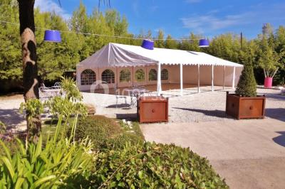 Château gonflable blanc installé sur une surface gravillonnée, entouré de végétation et de mobilier de jardin.