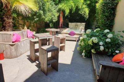 Château gonflable blanc installé sur une surface gravillonnée, entouré de végétation et de mobilier de jardin.